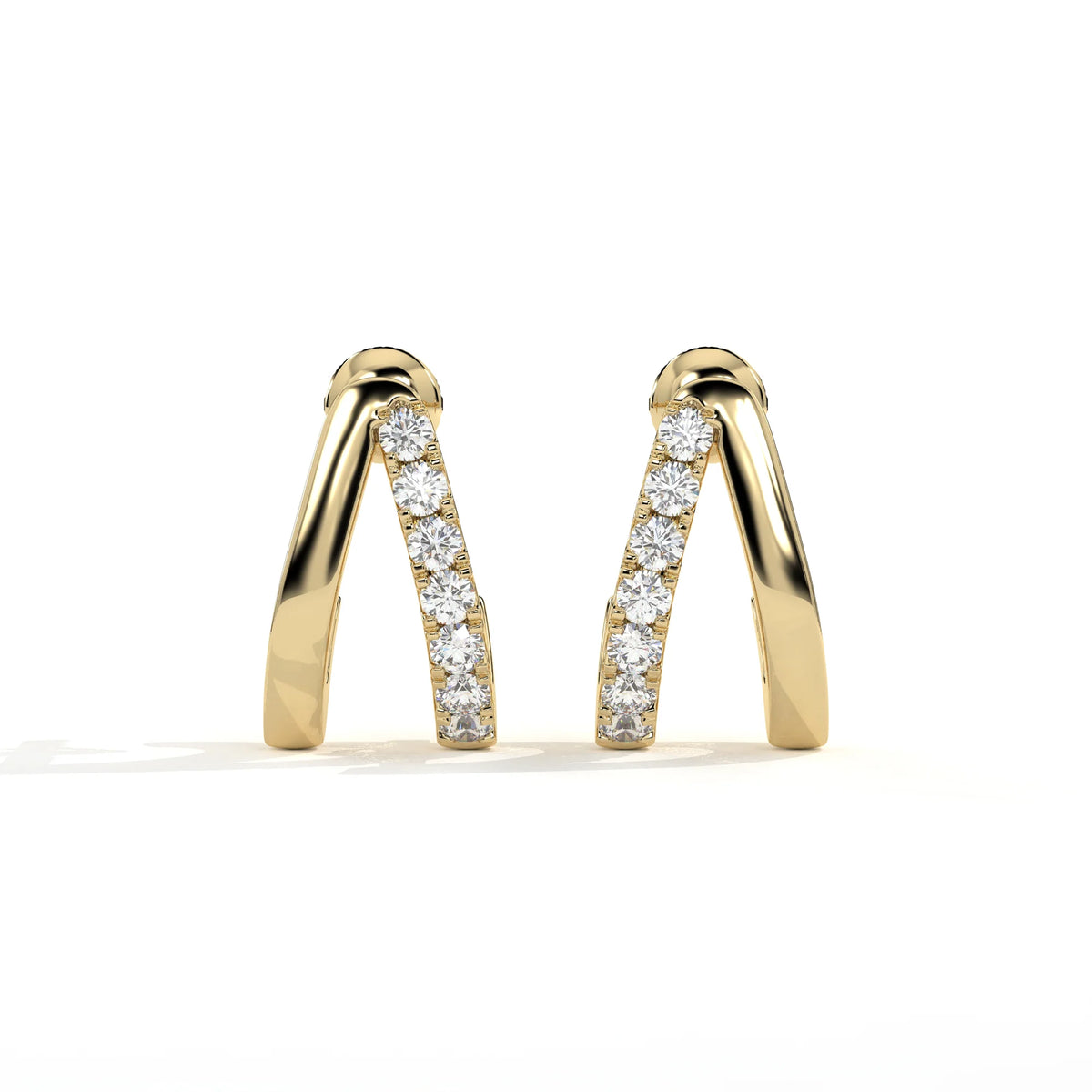 A pair of gold huggie earrings with a channel-set row of clear round diamonds, photographed on a clean white background.