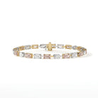 Gold and white gold tennis bracelet with diamonds alternating between oval-cut diamond, east-west emerald-cut pink diamond, east-west emerald-cut diamond, east-west emerald-cut pink diamond, repeating. The clasp is gold.