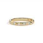A yellow gold eternity ring featuring a row of round-cut clear gemstones, photographed on a clean white background with a soft shadow.