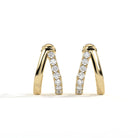 A pair of gold huggie earrings with a channel-set row of clear round diamonds, photographed on a clean white background.