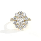 A yellow gold diamond ring with a large oval center stone surrounded by a halo of round diamonds, set on a plain white background with a soft shadow.